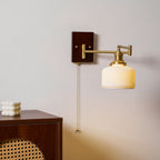 Ceramic wall lamp with pull chain shown against a neutral wall