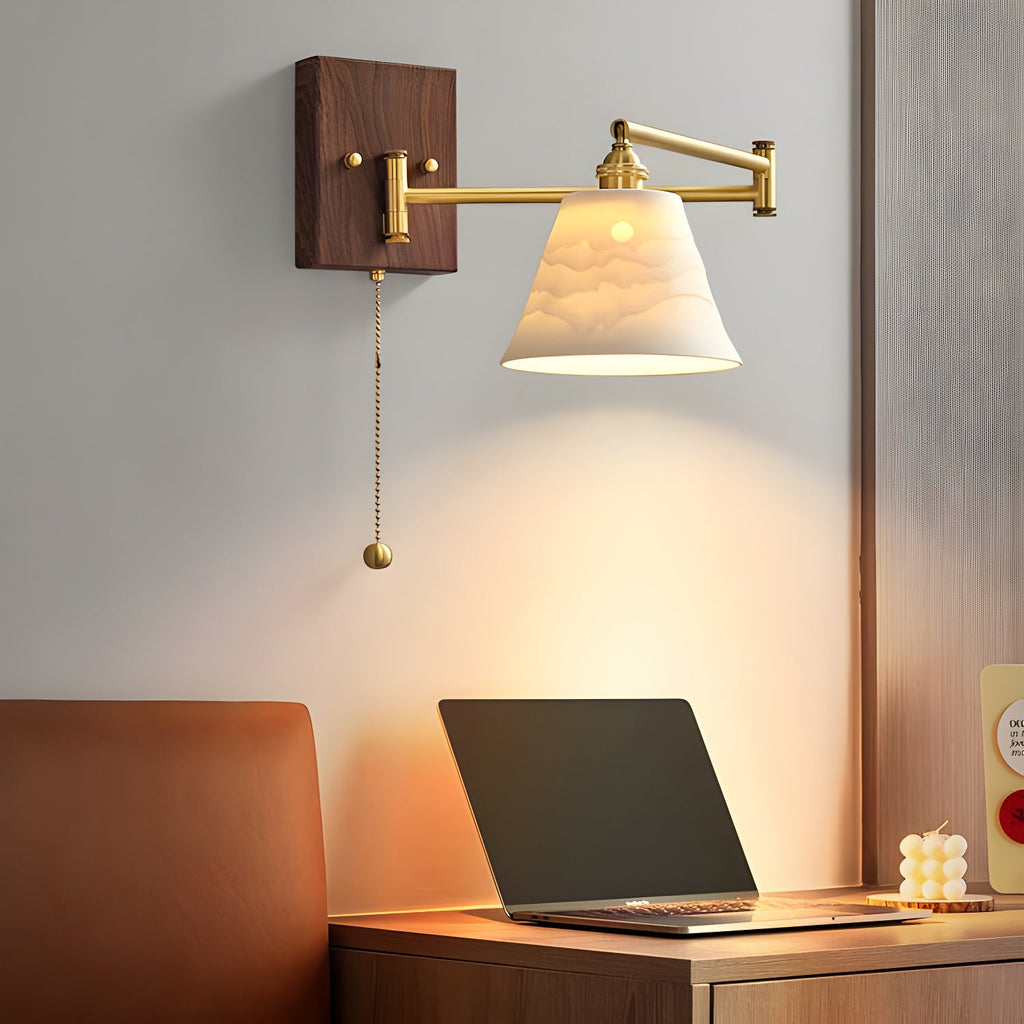 Ceramic wall lamp with brass and walnut casting a soft warm glow