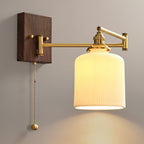 Ceramic wall lamp with brass arm and walnut accent against a wall