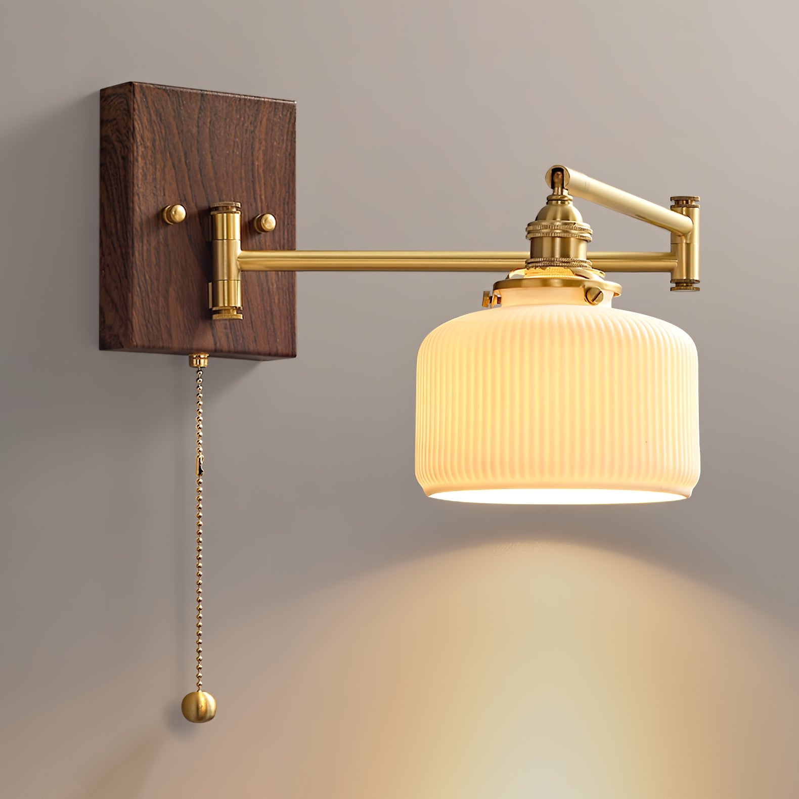 Ceramic wall lamp glowing warmly with brass and walnut fittings