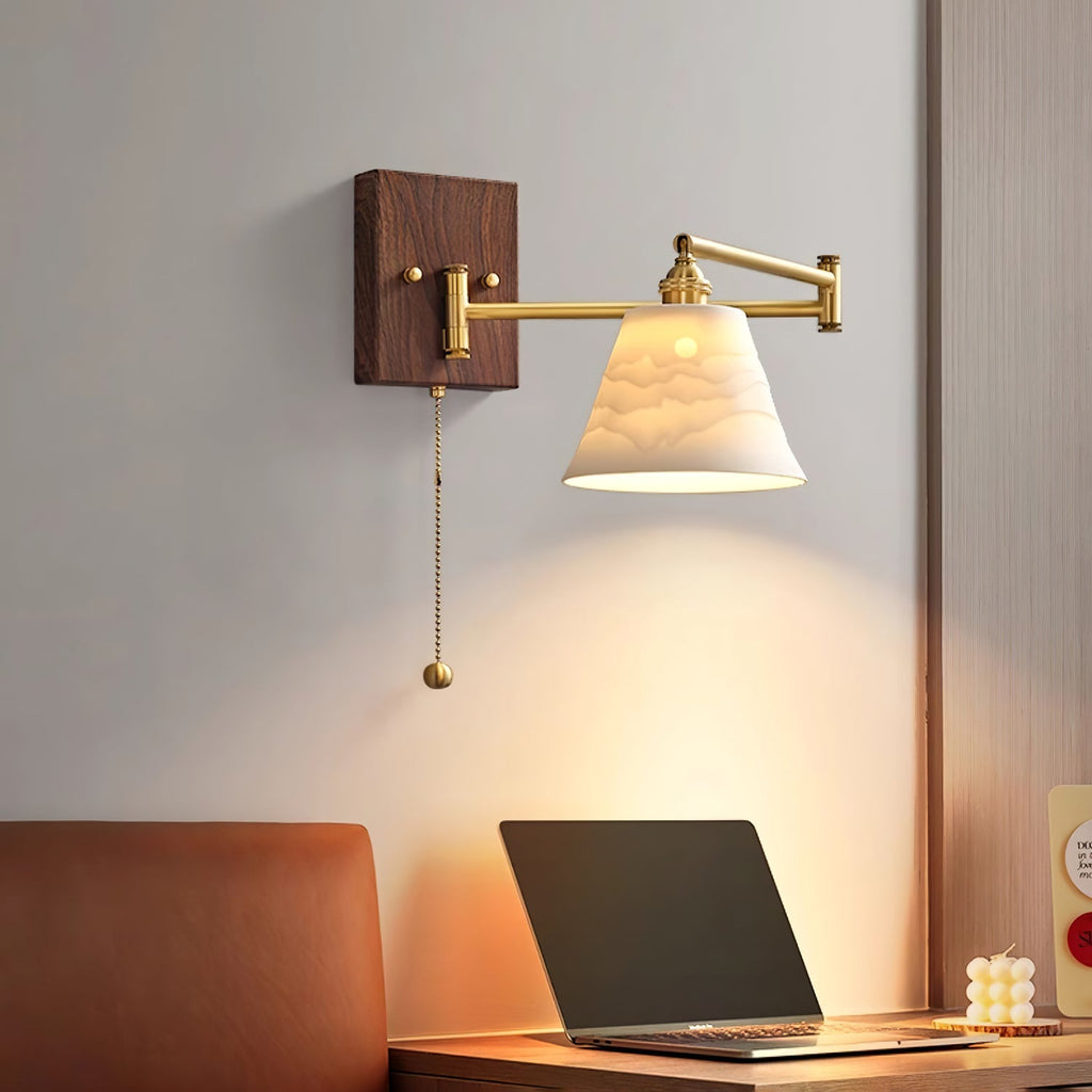 Ceramic wall lamp with walnut accent casting warm light on a wall