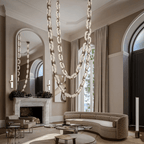 Chain-link chandelier draped in swags across a tall living room with a marble fireplace