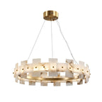 The ring chandelier straight on, alabaster tiles stepped around the polished brass band.