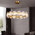 The chandelier lit in a concrete-walled room beside long curtains and a dark armchair.