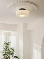 Glass shade ceiling light on black frame over a styled dining area