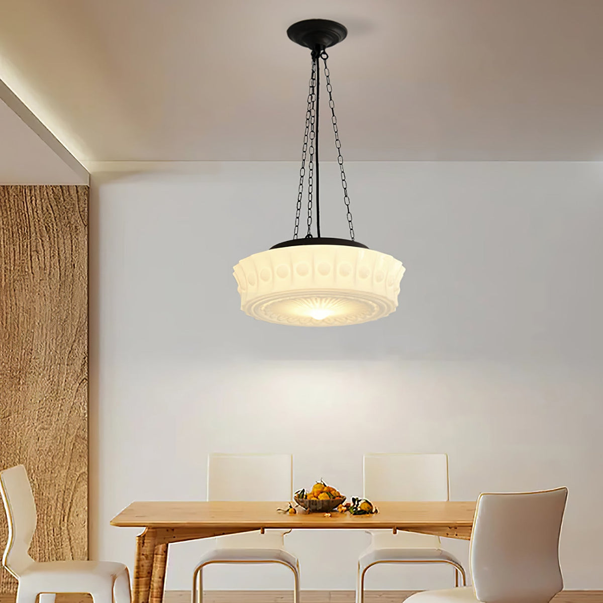 In a corner beside a wood-panelled wall, this beige fluted-glass Clérachic pendant glows above a dining table with white chairs.