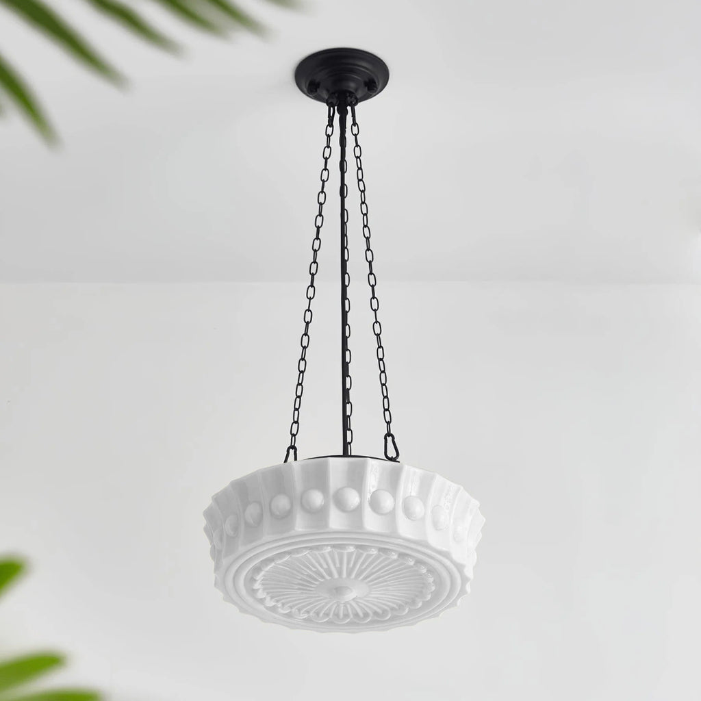 Angled on a plain background, this white fluted-glass Clérachic pendant's sunburst diffuser is visible from underneath, unlit.