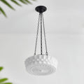 Angled on a plain background, this white fluted-glass Clérachic pendant's sunburst diffuser is visible from underneath, unlit.