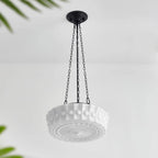 Angled on a plain background, this white fluted-glass Clérachic pendant's sunburst diffuser is visible from underneath, unlit.