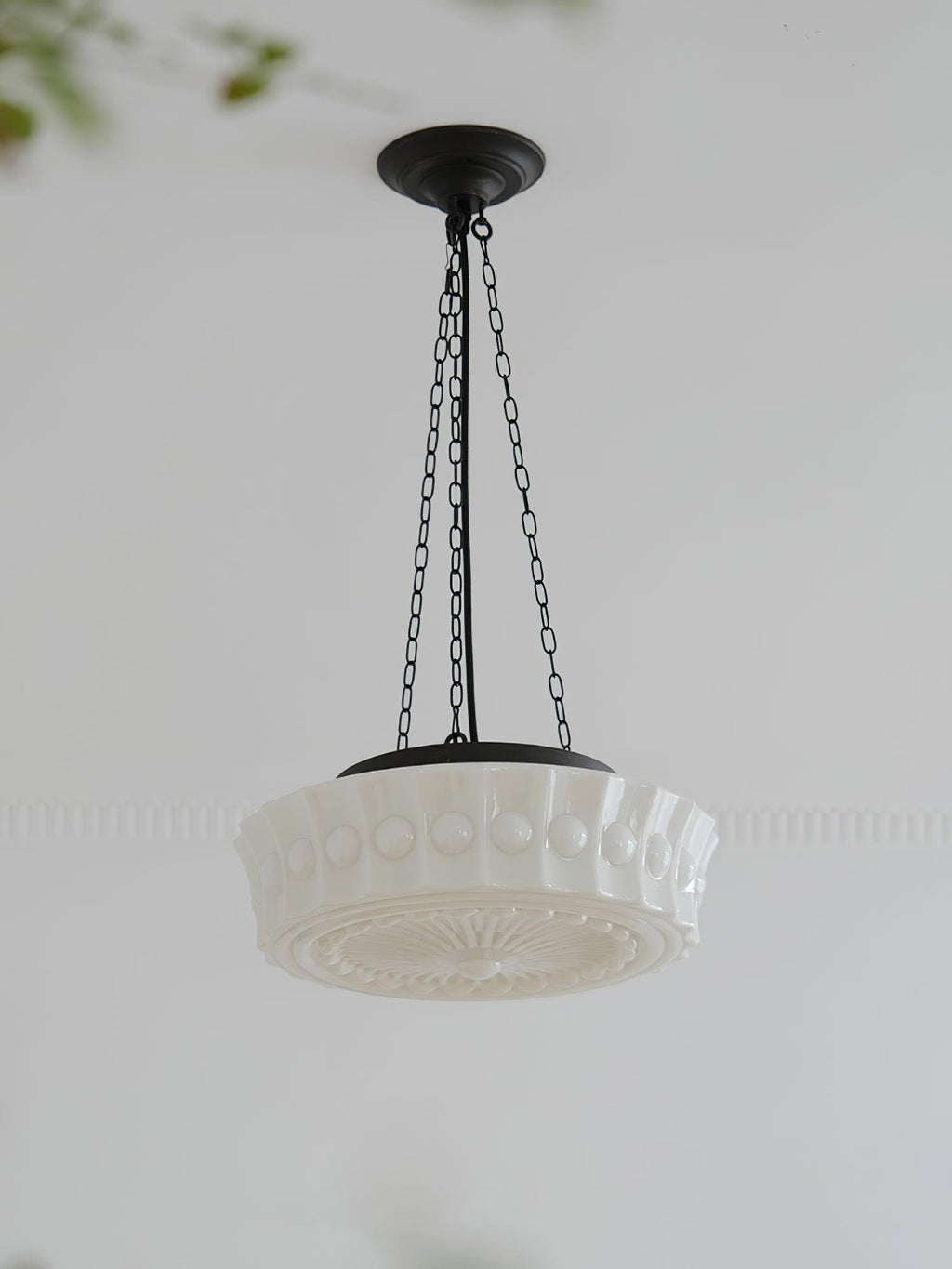 A low-angle studio view of this white fluted-glass Clérachic pendant, its ribbed edge and canopy set against a plain background.