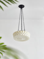 Viewed from below on a plain background, this white fluted-glass Clérachic pendant's sunburst diffuser plate is clearly visible.