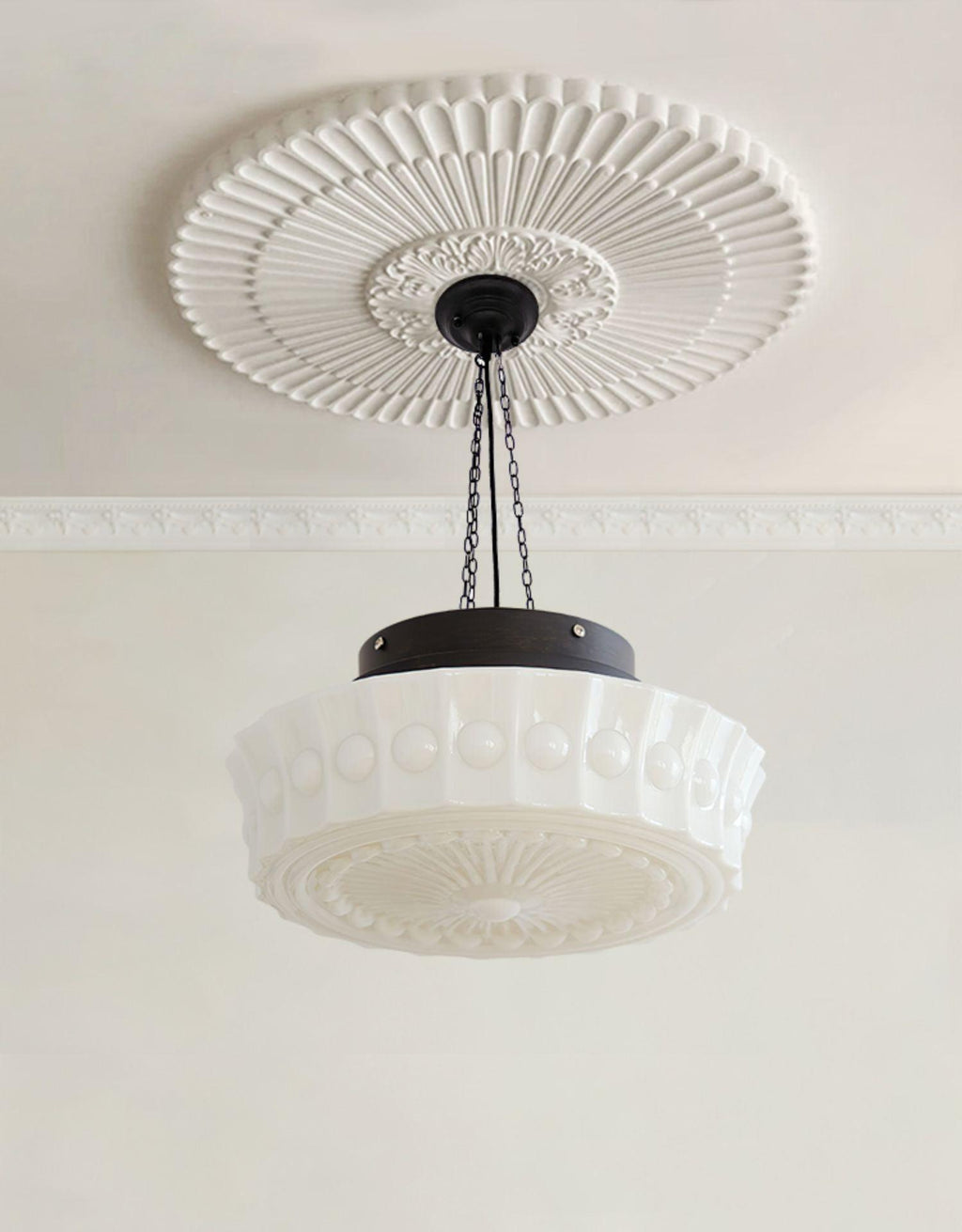 Beneath a large ribbed ceiling medallion, this beige fluted-glass Clérachic pendant's chains meet a black canopy.