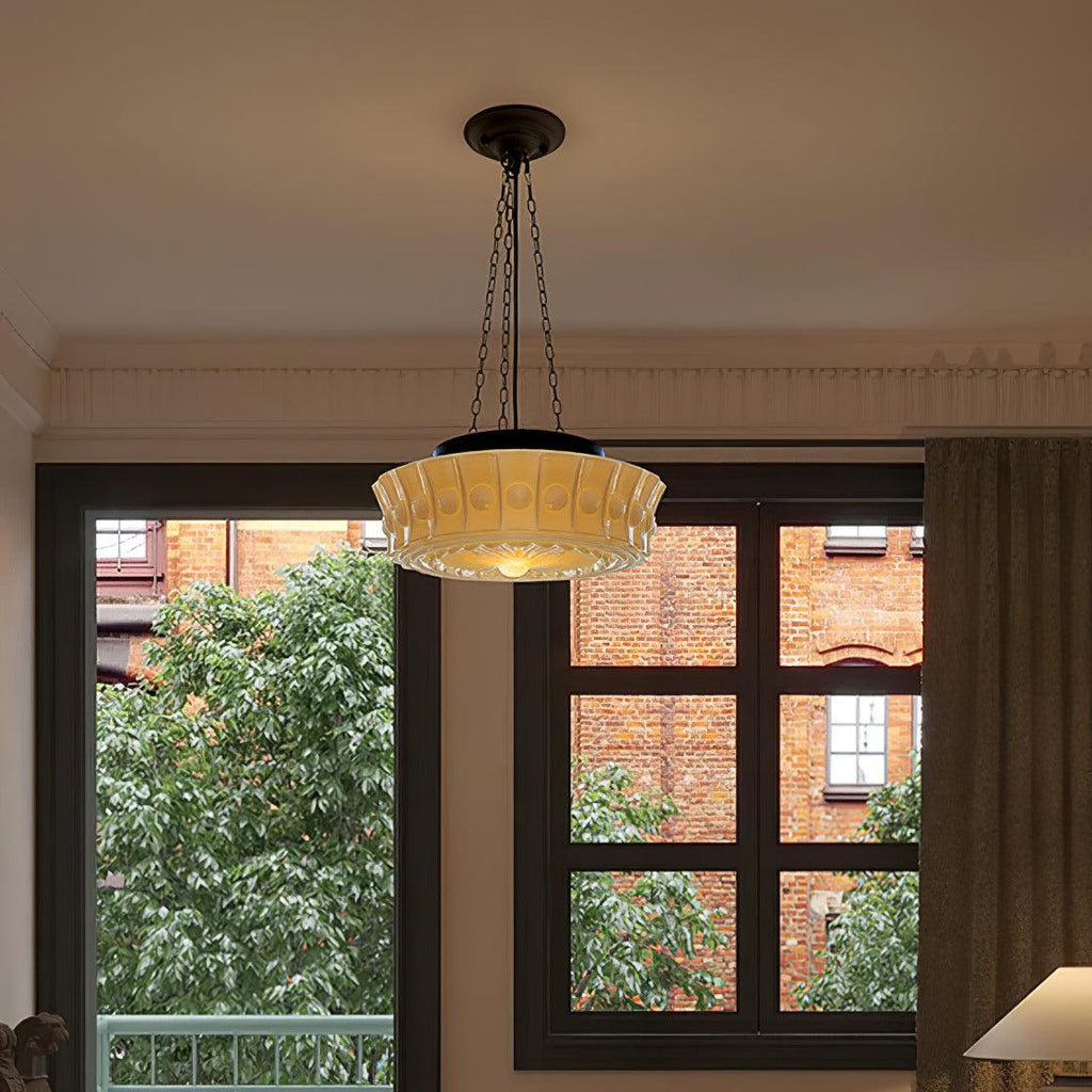 In front of a large window overlooking bare branches and a brick building, this beige fluted-glass Clérachic pendant hangs.