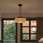 In front of a large window overlooking bare branches and a brick building, this beige fluted-glass Clérachic pendant hangs.