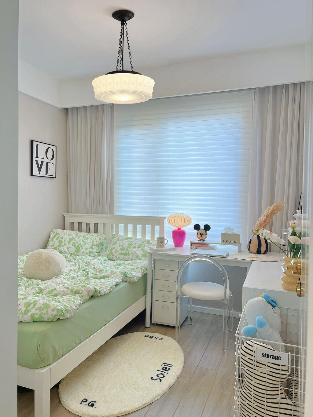 In a child's bedroom in front of a window, this beige fluted-glass Clérachic pendant hangs above green-patterned bedding.