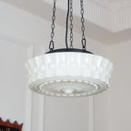 In a doorway, this white fluted-glass Clérachic pendant hangs lit, its sunburst diffuser plate clearly visible from below.