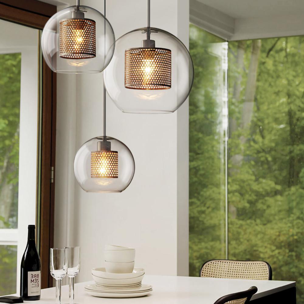 Blown glass pendant light with metal stem casting soft warm light
