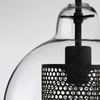Glass pendant light glowing softly over a styled dining table