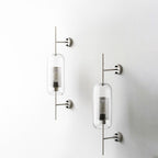 Hand-cut glass wall light with slim metal stem lit gently