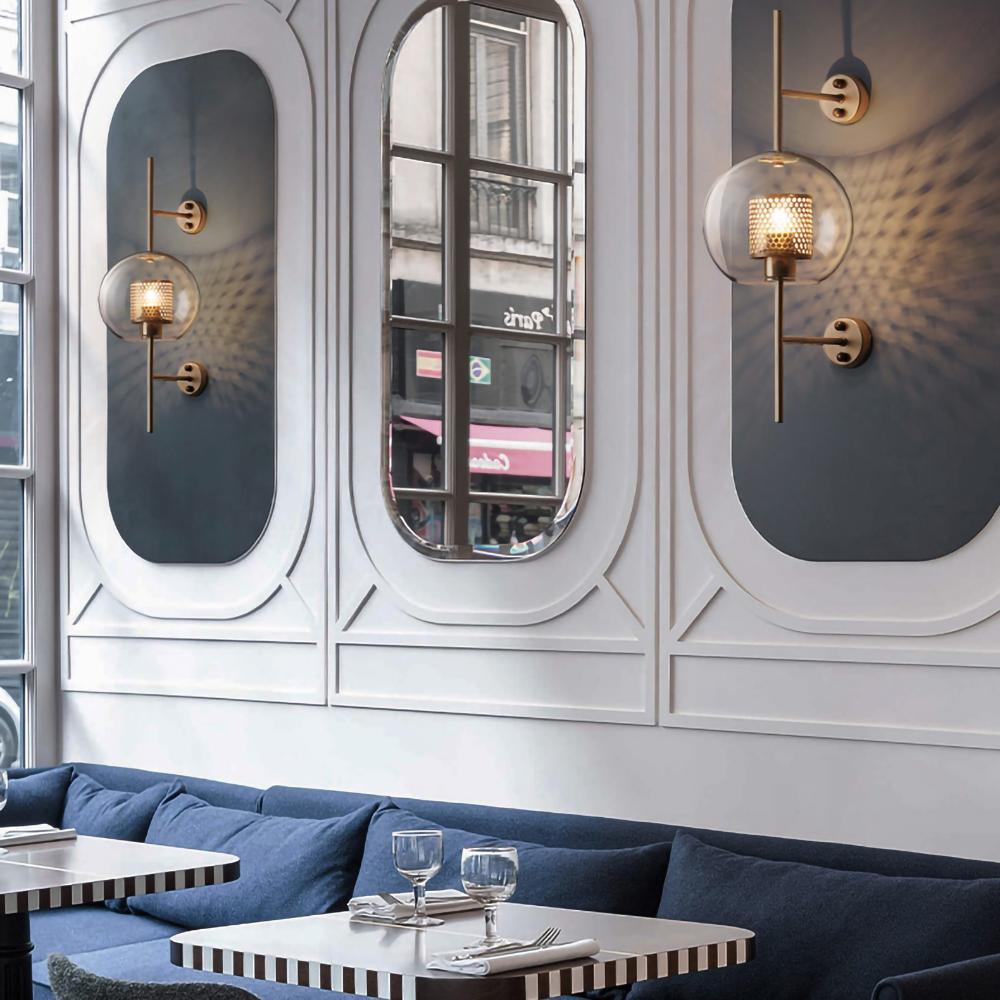 Hand-cut glass wall light with metal stem in a styled room