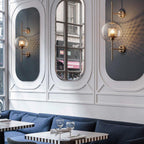 Hand-cut glass wall light with metal stem in a styled room