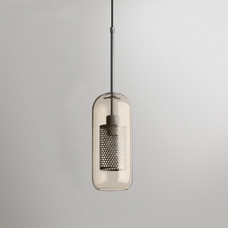 Glass pendant light with metal stem casting warm light indoors