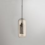 Glass pendant light with metal stem casting warm light indoors