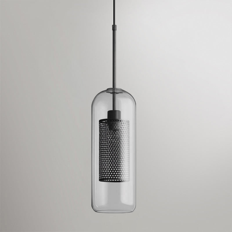 Glass pendant light with slim metal stem lit warmly in a room
