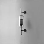Hand-cut glass wall light with slim metal stem lit softly indoors