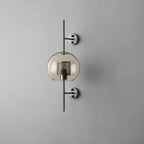 Glass wall light with metal stem casting soft light on a wall