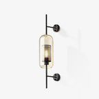Glass wall light with metal stem shown against a neutral wall