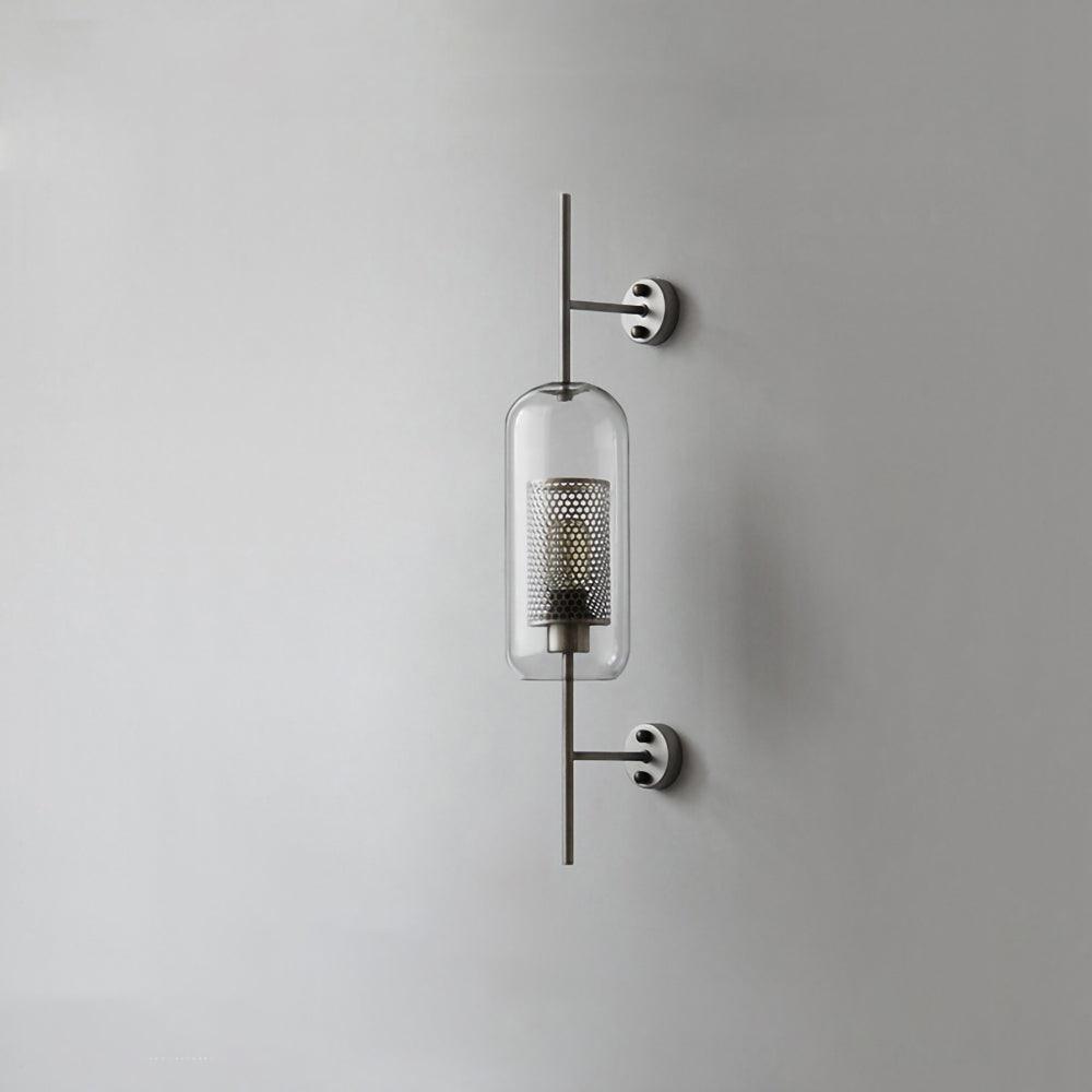 Capsule glass wall light in silver with clear shade glowing softly