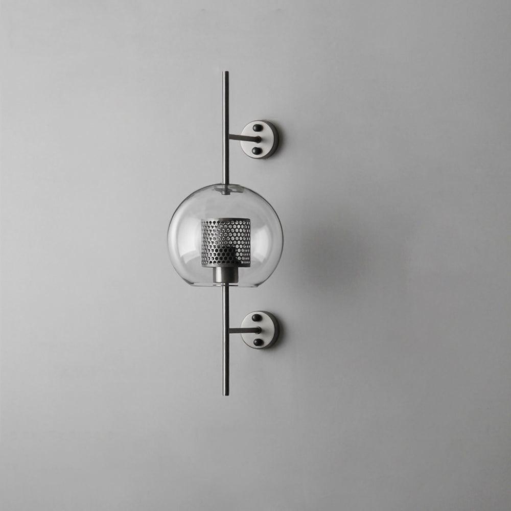 Sphere glass wall light in silver with clear glass shade lit warmly