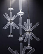 Three Clérachic pendants cluster together, unlit, their crystal rods layered against a dark wall.
