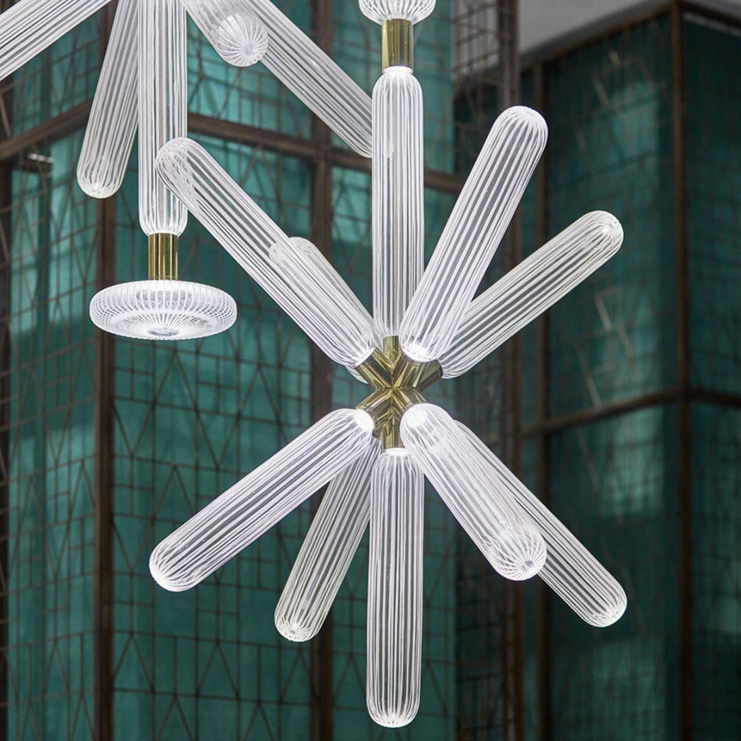 Close view of this Clérachic pendant's ribbed crystal rods against a jade-green glass screen.