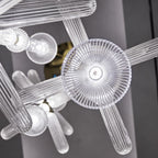 Close view of this Clérachic pendant's ribbed rods meeting a round disc cap and small glass finials.