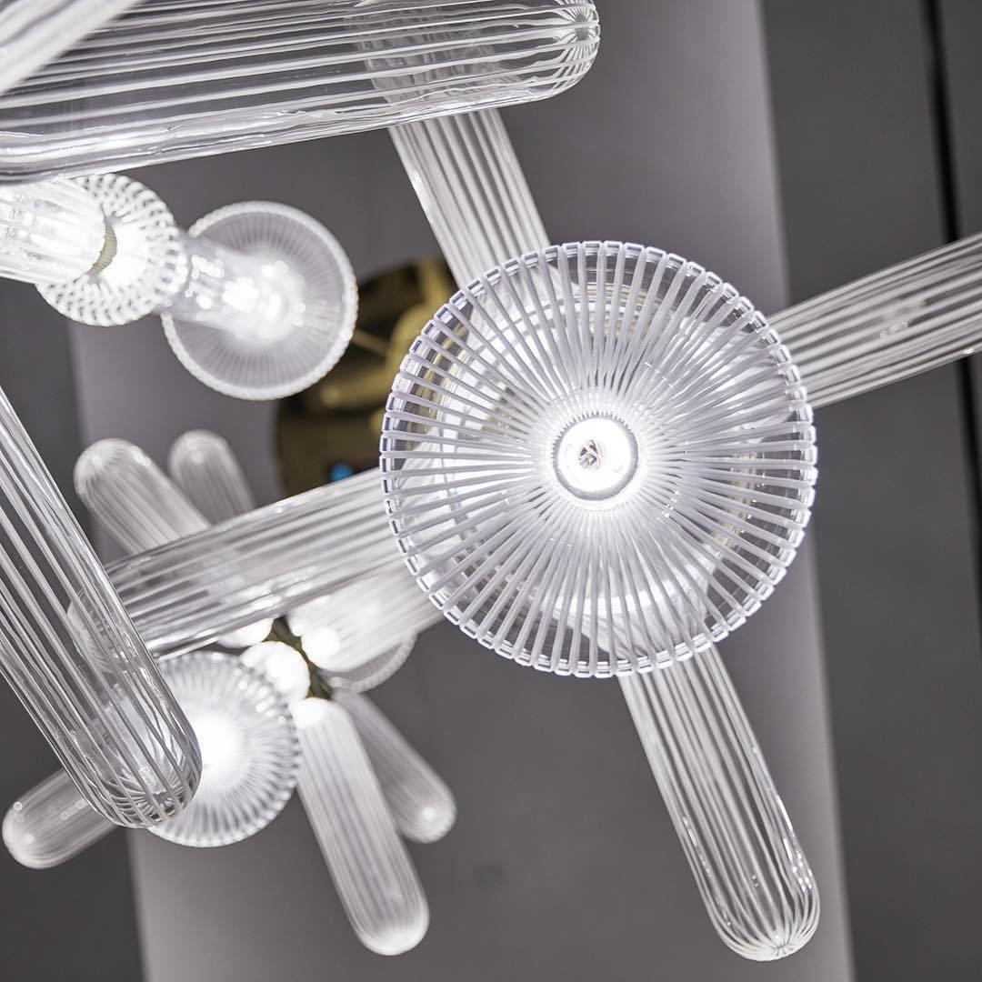 Close view of this Clérachic pendant's ribbed rods meeting a round disc cap and small glass finials.