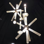 This Clérachic pendant's crystal rods glow warmly, clustered together against a black backdrop.
