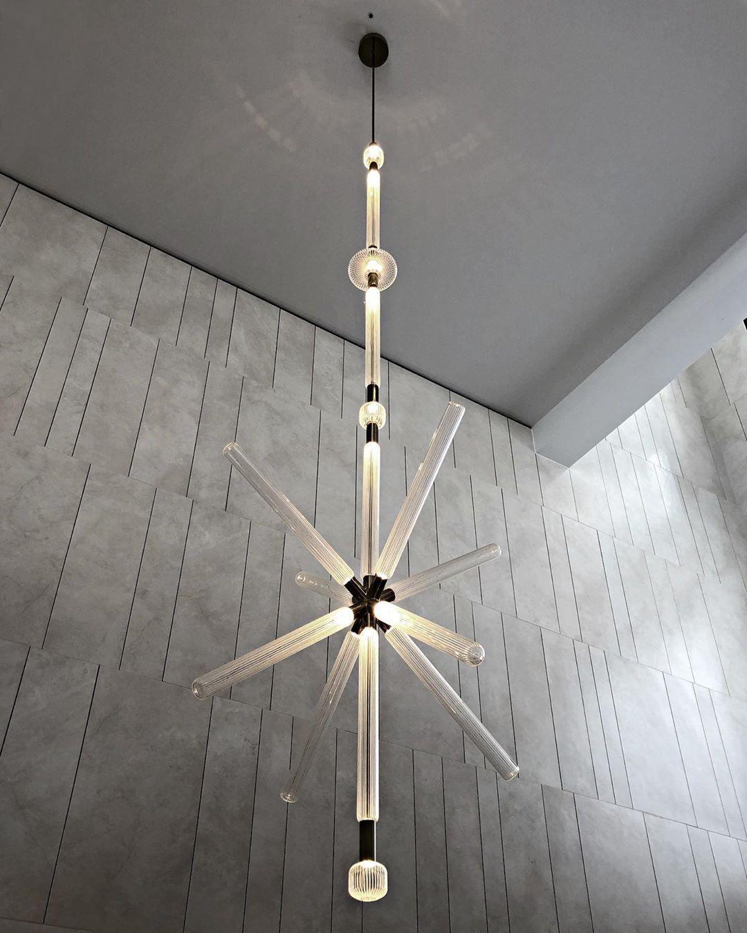 This Clérachic pendant drops from an angled ceiling, its crystal rods bursting low near the floor.