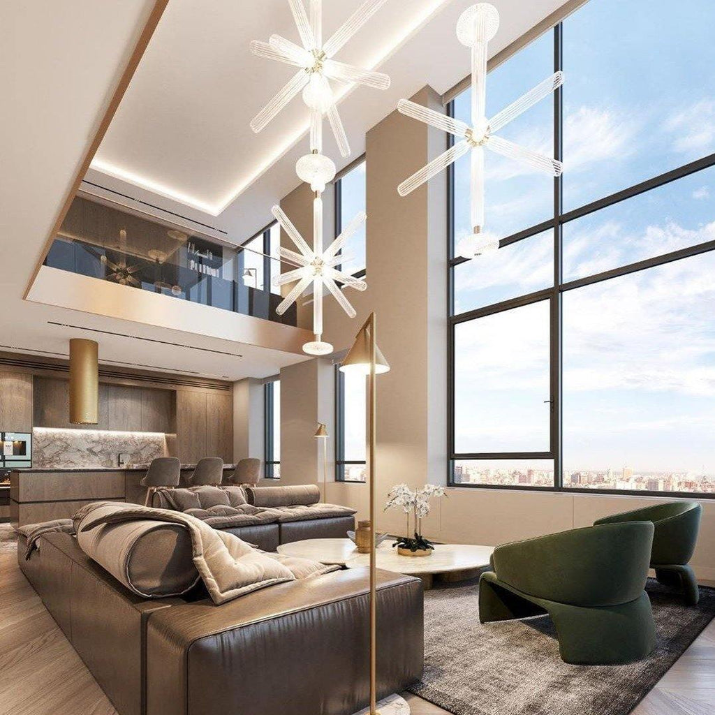 This Clérachic pendant hangs lit high above a living room sofa, seen through floor-to-ceiling windows.