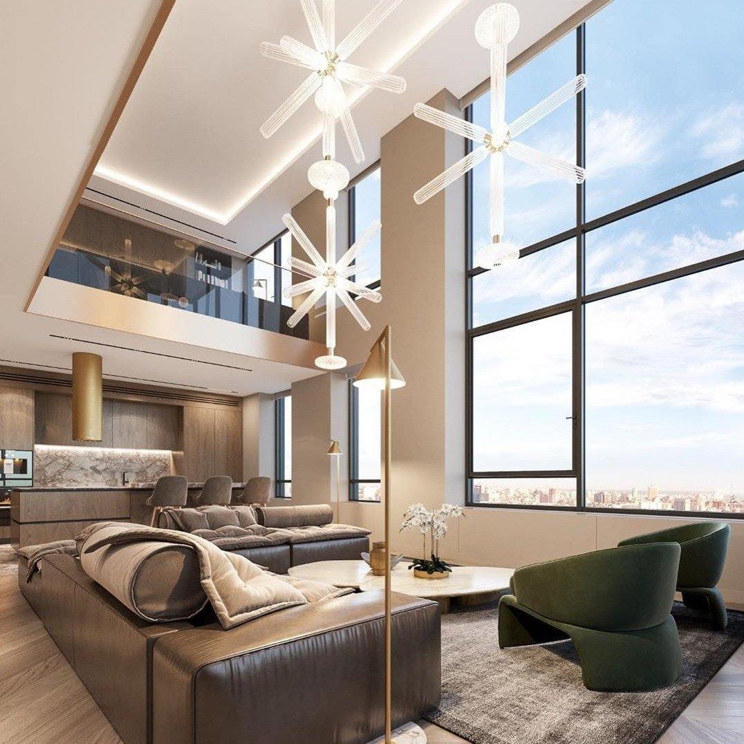 This Clérachic pendant hangs lit high above a living room sofa, seen through floor-to-ceiling windows.