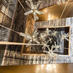 Looking down a stairwell at several Clérachic pendants lit against dark marble and brass trim.