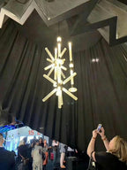This Clérachic pendant hangs lit at a trade-show display, its crystal rods glowing above onlookers.