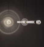 This Clérachic pendant glows against a dark wall, its light spreading in soft rings behind it.