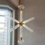 A six-armed Clérachic pendant hangs lit near a window, its crystal rods radiating from a gold centre.