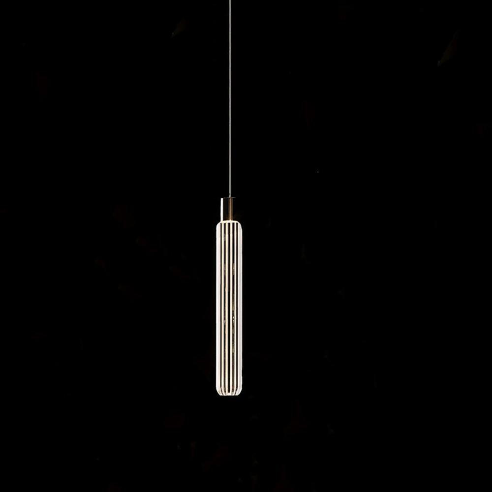 This Clérachic pendant's fluted glass cylinder glows against a black backdrop.