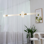 Sheer curtains and a potted plant frame this lit Clérachic pendant's fluted glass bar.