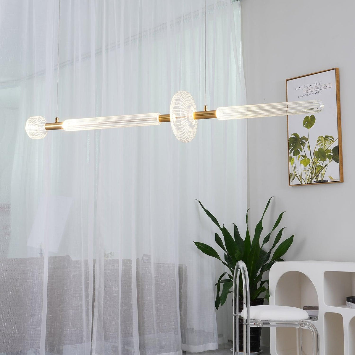 Sheer curtains and a potted plant frame this lit Clérachic pendant's fluted glass bar.