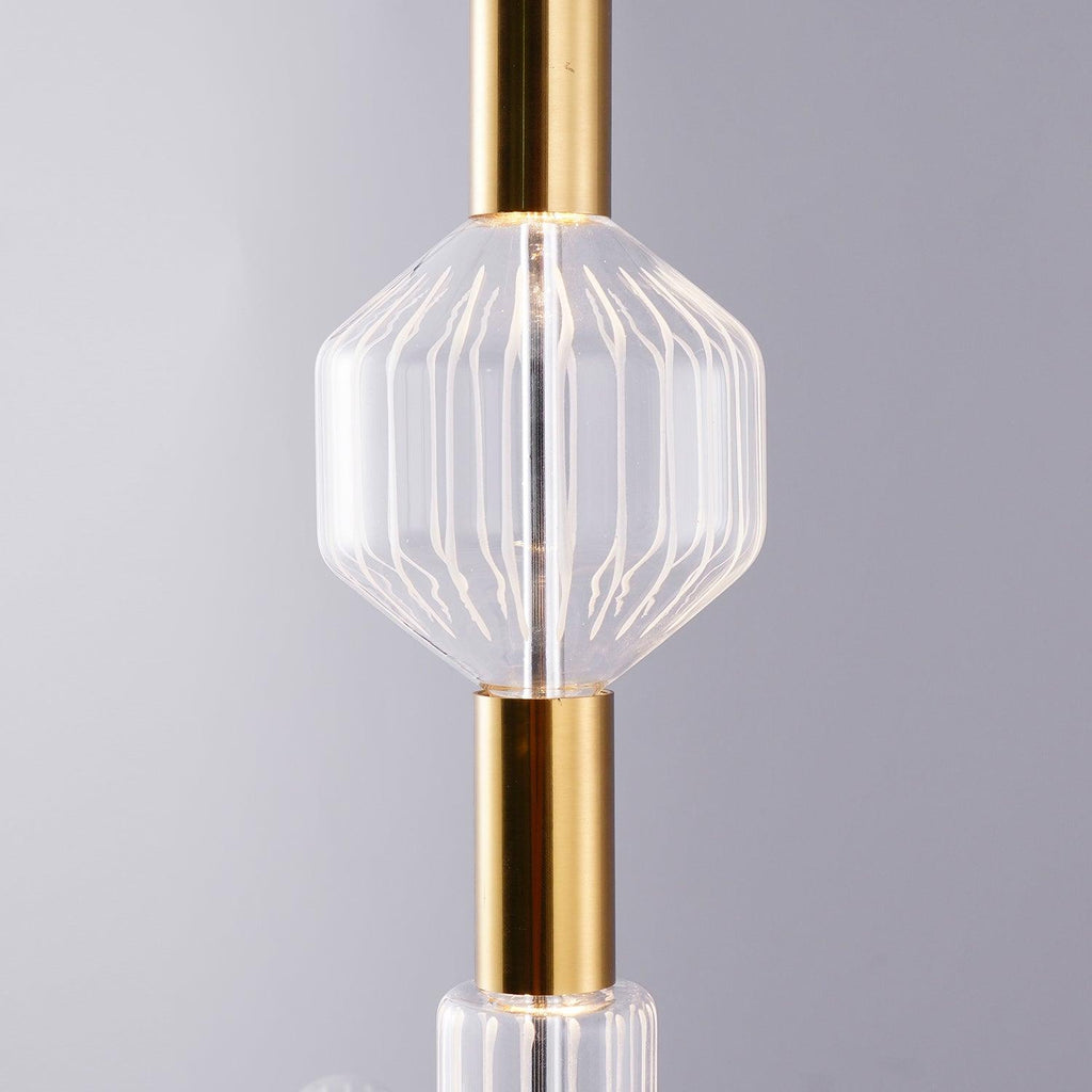 Close view of an angular ribbed glass shade on this Clérachic pendant's gold connector.