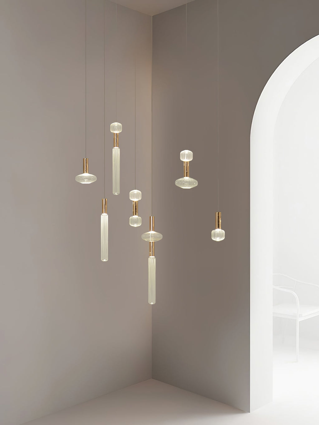 Small Clérachic pendants cluster at staggered drops in a curved white alcove.